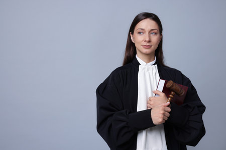 Judge with mallet and book on gray background, space for textの写真素材