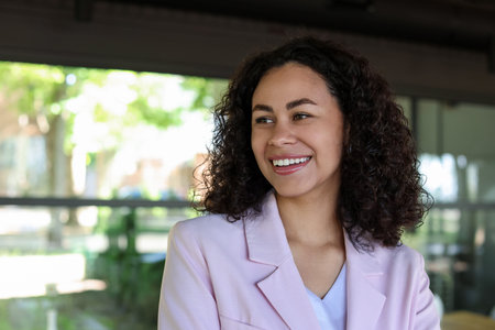 Portrait of smiling Latin American woman in cafe. Space for textの写真素材