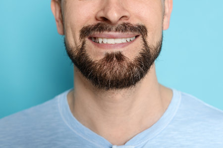 Smiling man before shaving on light blue background, closeupの写真素材