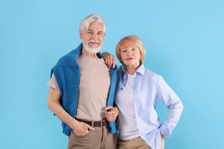 Lovely senior couple together on light blue background