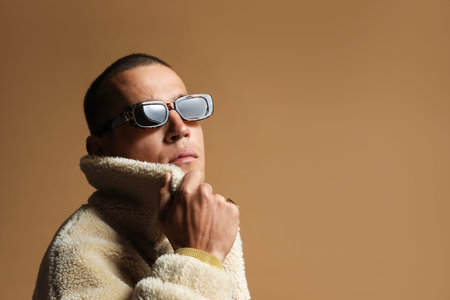 Fashionable portrait of handsome man in stylish outfit on brown background, space for text