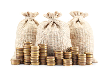 Bags and stacked coins isolated on whiteの写真素材