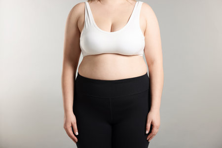 Weight loss. Plus size woman on gray background, closeupの写真素材