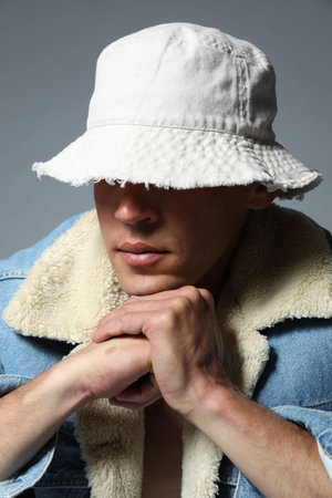 Fashionable portrait of handsome man in stylish outfit on grey background
