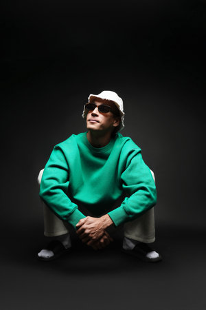 Fashionable portrait of handsome man in stylish outfit on black backgroundの写真素材