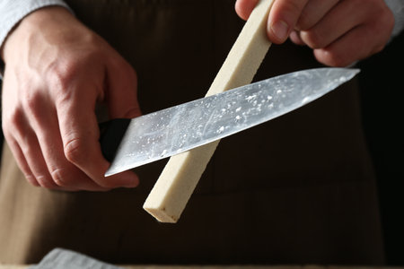 Man sharpening knife with sharpener, closeup viewの写真素材