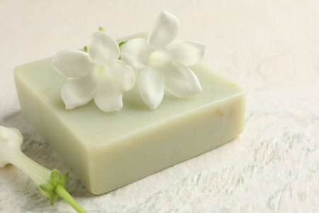 Bar of soap and jasmine flowers on light table, closeupの写真素材