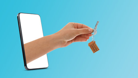 Real estate services online. Woman's hand with key sticking out from smartphone on light blue...