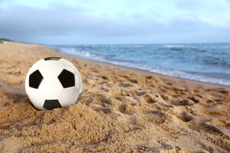 Beach football. Soccer ball on sand near sea. Seasonal outdoor activityの写真素材