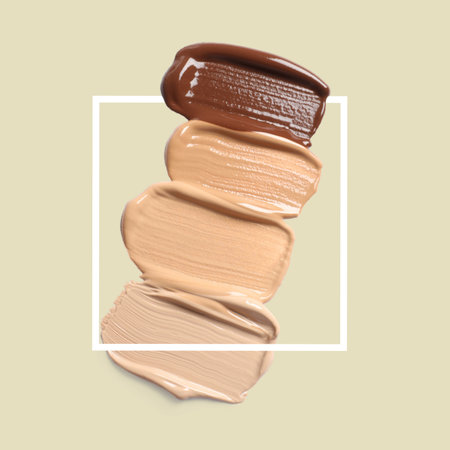 Different shades of foundation and frame on pastel olive background. Color palette of makeup productの写真素材