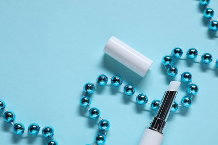 Moisturizing lip balm and Christmas decor on light blue background, flat lay. Space for textの写真素材