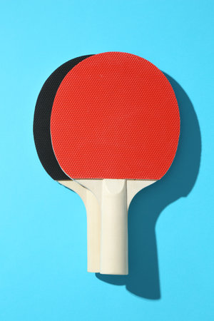 Ping pong rackets on blue background, top viewの写真素材