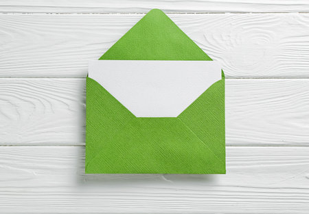 Blank invitation card and envelope on white wooden table, top viewの写真素材