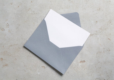 Blank invitation card and envelope on light grey table, top view. Space for designの写真素材