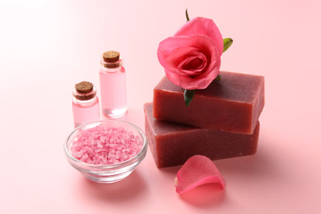 Soap bars, cosmetic products and beautiful rose on pink background, closeupの写真素材