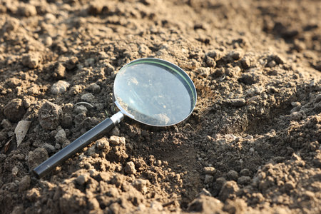 Magnifying glass on dry soil in fieldの写真素材