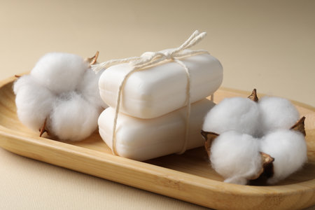 Soap bars and cotton flowers on beige background, closeupの写真素材