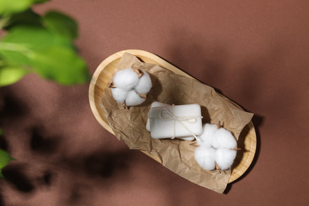 Soap bars and cotton flowers on brown background, top viewの写真素材