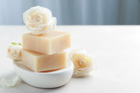 Aromatic soap bars and roses on light tableの写真素材
