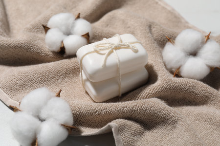 Soap bars, towel and cotton flowers on table, closeupの写真素材