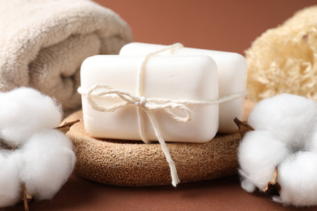 Composition with white soap bars and cotton flowers on brown background, closeupの写真素材