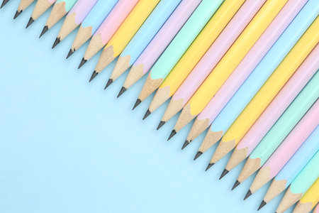 Many pencils on light blue background, flat lay. Space for textの写真素材