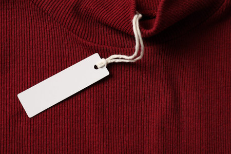 Cardboard tag on red garment, top view