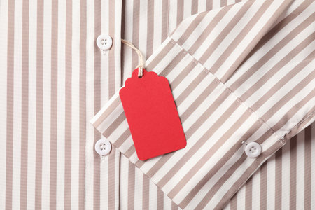 Cardboard tag on striped shirt, top viewの写真素材
