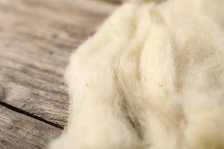 Natural felting wool on wooden background, closeup