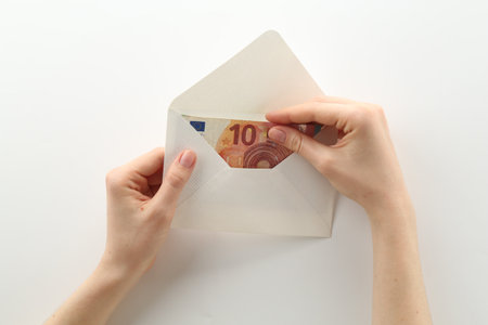 Money bonus. Woman holding envelope with euro banknotes on white background, closeupの写真素材