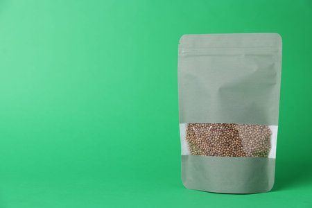 One zipper stand-up pouch with seeds on green background. Mockup for design