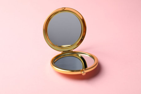 Open pocket mirror on pink background, closeupの写真素材