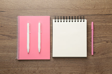 Notebooks and pens on wooden table, flat layの写真素材