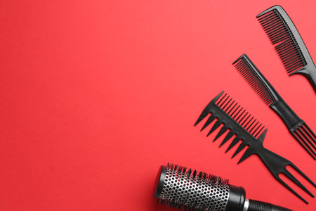 Different hairdresser's tools on red background, flat lay. Space for textの写真素材
