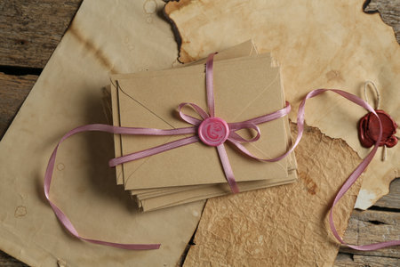 Stack of love letters and parchment sheets on wooden table, top viewの写真素材