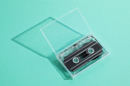 One audio cassette in open box on turquoise background, above viewの写真素材