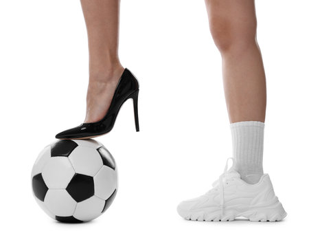 Woman in high heeled shoe and sneaker with soccer ball on white background, closeupの写真素材