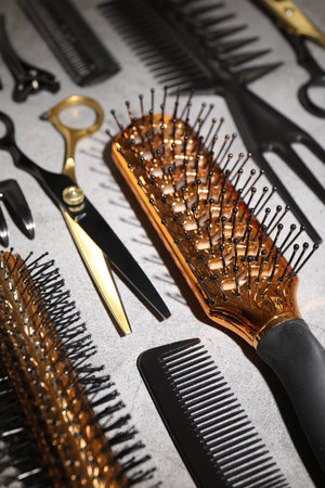 Different hairdresser's tools on gray table, closeup