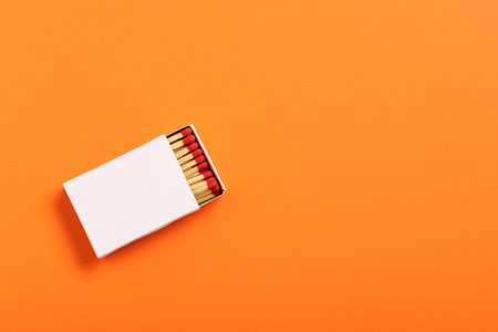 Matches in box on orange background, top view. Mockup for designの写真素材