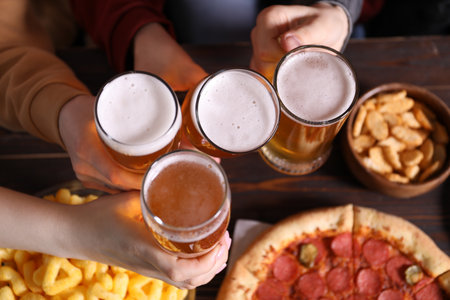 Friends with beer and snacks at wooden table, top viewの写真素材
