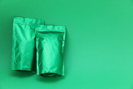 Zipper stand-up pouches on green background, top view. Mockup for designの写真素材