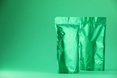 Zipper stand-up pouches on green background. Mockup for designの写真素材