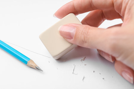 Woman using eraser on white paper, closeupの写真素材