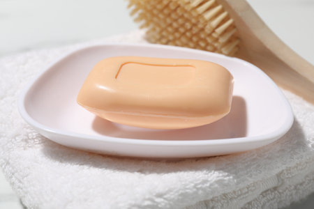 Soap bar, brush and towel on table, closeupの写真素材