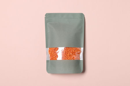 One zipper stand-up pouch with lentils on pink background, top view. Mockup for design