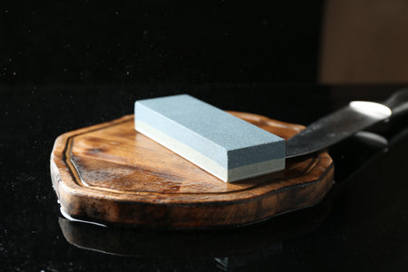 Sharpener and knife on black mirror surface, closeupの写真素材