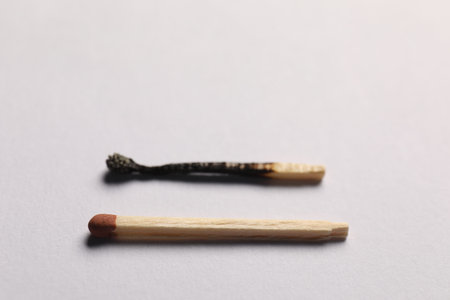 Burnt and whole matches on gray background, selective focusの写真素材