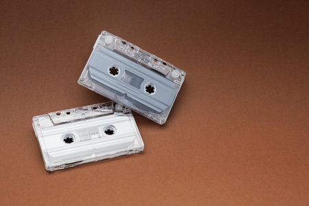 Audio cassettes with magnetic tapes on brown background. Space for textの写真素材