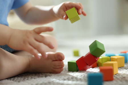 Cute little child playing with colorful cubes at home, closeupの写真素材
