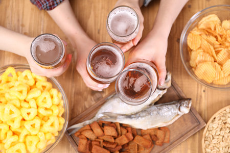Friends with beer and snacks at wooden table, top viewの写真素材